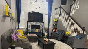 Uma sala de estar moderna com sofá, poltronas, mesa de centro e lareira.