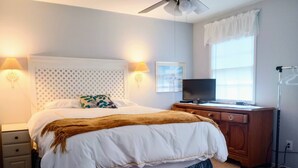 A bedroom with a bed, bedside lamps, a desk with a computer, a window with curtains, and a ceiling fan. - Local Events House on Lake near HPU, High Point Markets, NC Hospitals  (High Point)