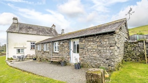 A stone cottage with a gravel driveway and a white exterior wall. - Shepherds Cottage (Ambleside)