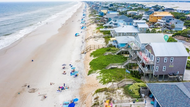 A coastal residential area with beach access, houses with balconies, and a pier extending into the water. - Hot Tub, BeachFront, Private, Hammocks on the Beach (Surf City)