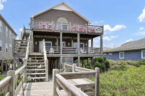 A two-story wooden building with a balcony and a wooden staircase leading to it.