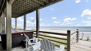 A wooden deck with Adirondack chairs overlooking a beach. - Hot Tub, BeachFront, Private, Hammocks on the Beach (Surf City)