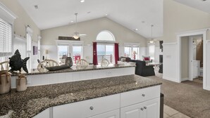 A spacious kitchen with granite countertops, white cabinetry, and a large island. - Hot Tub, BeachFront, Private, Hammocks on the Beach (Surf City)