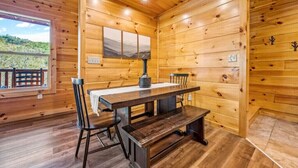 Un interior de madera con una mesa de comedor, sillas y un banco.