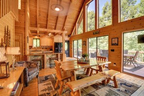 A spacious wooden cabin with a large dining table, a cozy seating area, and a kitchen. - Lakefront Six Mile Vacation Rental w/ Dock (Six Mile)