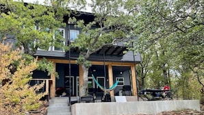 A modern house with a stone staircase leading to a wooden deck. - Lakehouse front property swim off pier!  (Cisco)