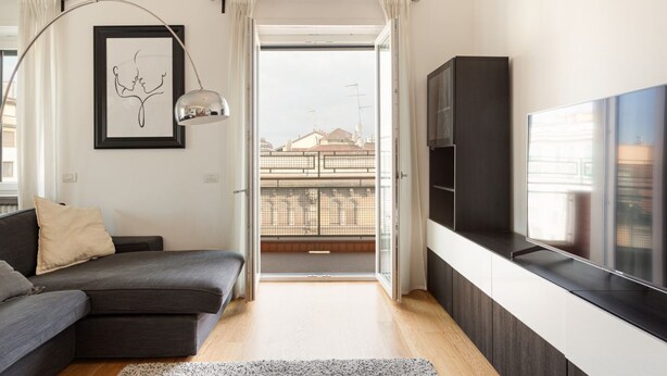 A modern living room with a sofa, a TV, a framed artwork, and a balcony view. - GuestHost - Bright, brand new Apartment- Milano Centrale (Milano)