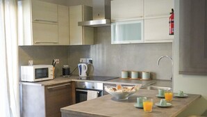 A compact kitchen with a central island, a microwave, a kettle, and a fire extinguisher. - Convenient Central 3BR Apt Near Bus Terminus (St. Paul's Bay)