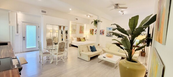 A modern living room with a sofa, coffee table, and dining area.