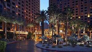 A hotel with multiple high-rise buildings, palm trees, and a well-lit entrance area. - Las Vegas | Pool & Strip Access | Urban Comfort Stay (Las Vegas)