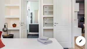 A hotel room with a bed, a bedside table with a lamp, a wardrobe, and a bathroom visible through an open door. - Gemelli Cozy quiet Home- well connected (Roma)