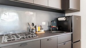 A modern kitchen with a gas stove, a sink, and a refrigerator. - Gemelli Cozy quiet Home- well connected (Roma)