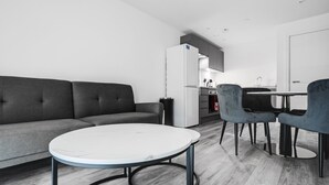 A modern living room with a grey sofa, a round white table, and two grey chairs. - GuestReady - Hideaway in Vauxhall (Liverpool)