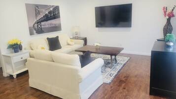 A living room with a sofa, coffee table, TV, and decorative items.