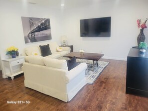 A living room with a sofa, coffee table, TV, and decorative items.