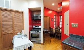 A compact kitchen with a stove, microwave, and wooden cabinets.