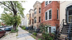 A row of townhouses with brick facades, a tree-lined sidewalk, and a parked car. - A Good Place To Stay! (Washington)