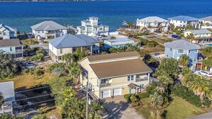 A coastal residential area with houses, some with balconies, and a view of the ocean.