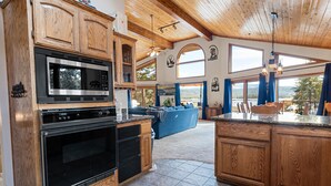 Une cuisine spacieuse avec des meubles en bois, un four à micro-ondes encastré et un grand îlot central.