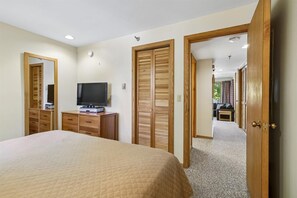 King Bedroom with Storage - This view highlights the TV, dresser and closet, with the hallway just outside the bedroom.