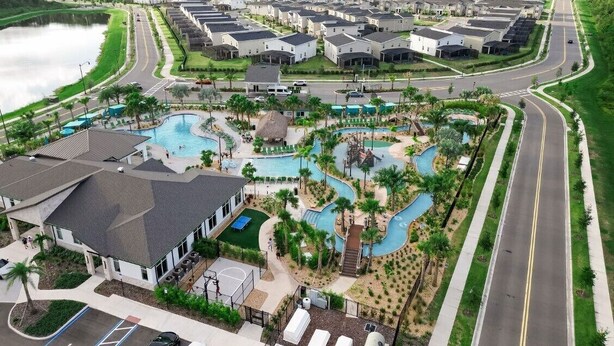 Een woonwijk met meerdere huizen, een zwembad en een weg.