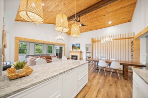 A modern kitchen with a large island, wooden ceiling, and pendant lighting. - A Red Chalet - Linville mountain chalet with game room, fireplace & year-round views (Newland)
