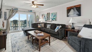A living room with a sofa, coffee table, and a ceiling fan.