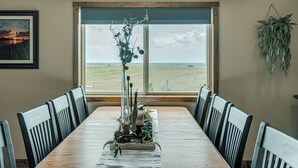 A dining table with chairs, a fish decoration, a plant, and a window with a view of the landscape. - Country Living with Modern Amenities and Hot Tub (Bismarck)