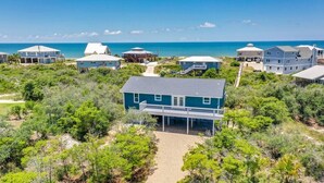 A coastal property with multiple houses, a central house with a covered porch, and a clear view of the ocean. - Sea 'n Stars Cape San Blas Vacation Rental (Port St. Joe)