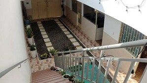 Un escalier menant à un balcon d’où l’on peut admirer une terrasse carrelée.