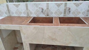 Une salle de bain avec deux lavabos, un miroir et un sol carrelé.
