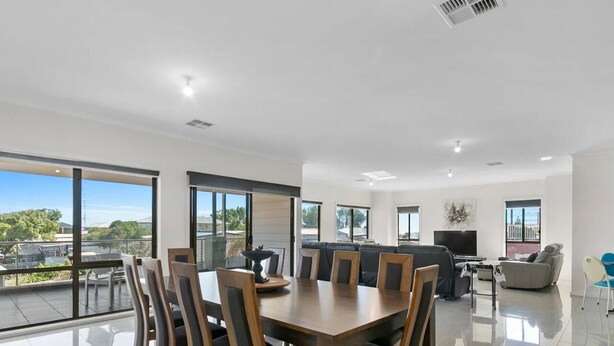A spacious living area with a dining table, sofas, and a TV. - Sleeps 14 - 3 minute walk to beach, 5 minute drive to "The Dunes" Golf Course  (Moonta Bay)