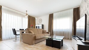 Un salon moderne comprenant un canapé, une table basse, un téléviseur et un coin repas.