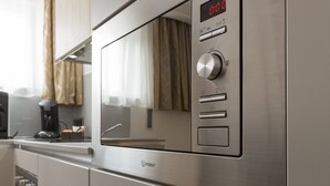 A stainless steel kitchen with a microwave, oven, and a coffee maker on the countertop.
