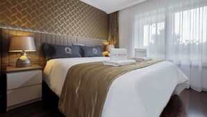 Una habitación de hotel con una cama grande, un cabecero con diseño decorativo, una mesita de noche con lámpara y un letrero que dice 'The Queen'.