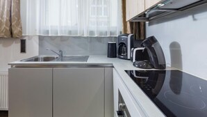 Una cocina moderna con estufa integrada, cafetera y pileta.