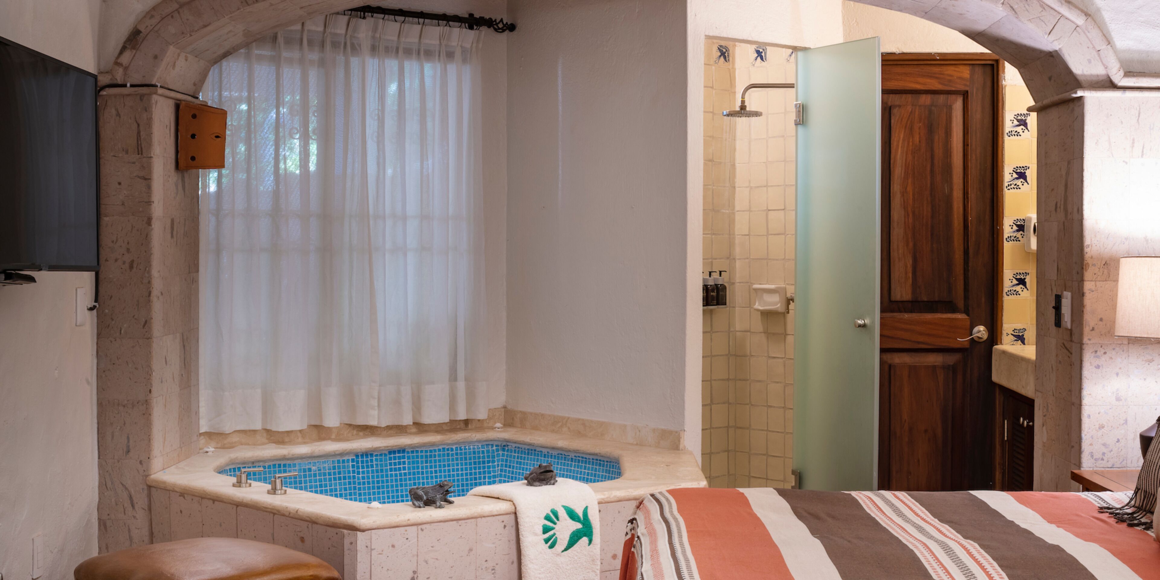 A bathroom with a bathtub, a shower, and a wooden door.