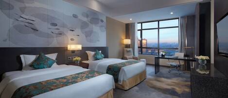 A hotel room with two beds, a desk, a chair, a TV, and a large window with a city view.
