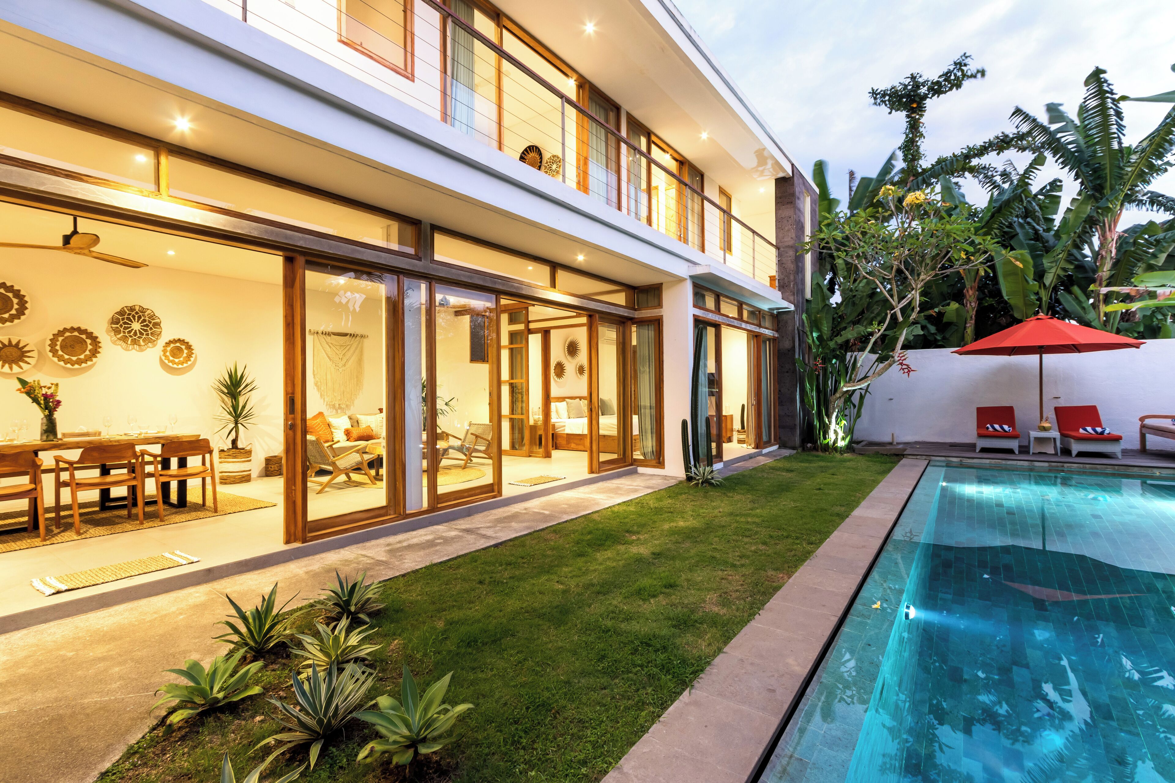 A modern house with a swimming pool, a dining area, and a well-maintained garden.