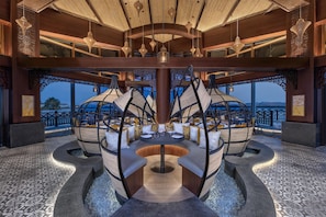 A modern interior with a central seating area, wooden ceiling, and large windows. - Anantara Mina Ras Al Khaimah Resort (Ras Al Khaimah)
