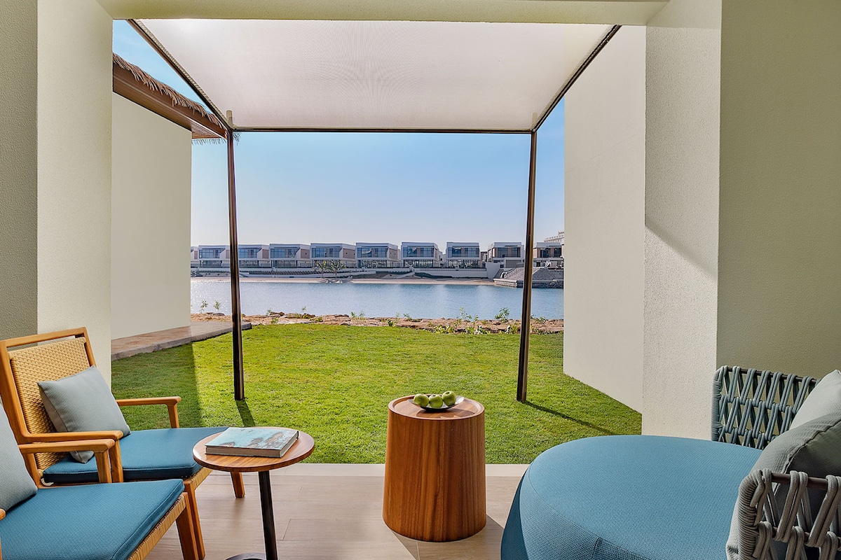 Un balcon agrémenté de meubles en osier, une petite table ronde et une vue sur un port de plaisance.