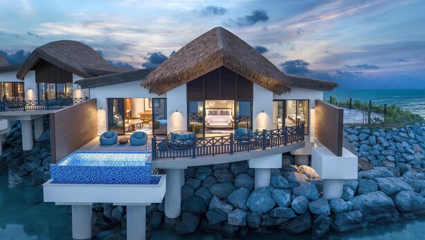 A luxurious overwater villa with a thatched roof, a private infinity pool, and a balcony overlooking the sea. - Anantara Mina Ras Al Khaimah Resort (Ras Al Khaimah)