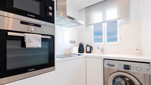Una cocina compacta equipada con horno Bosch, cafetera y lavadora.