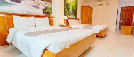 Habitación de hotel con dos camas de madera, un mural grande de una cascada, un armario de madera y piso de baldosas.