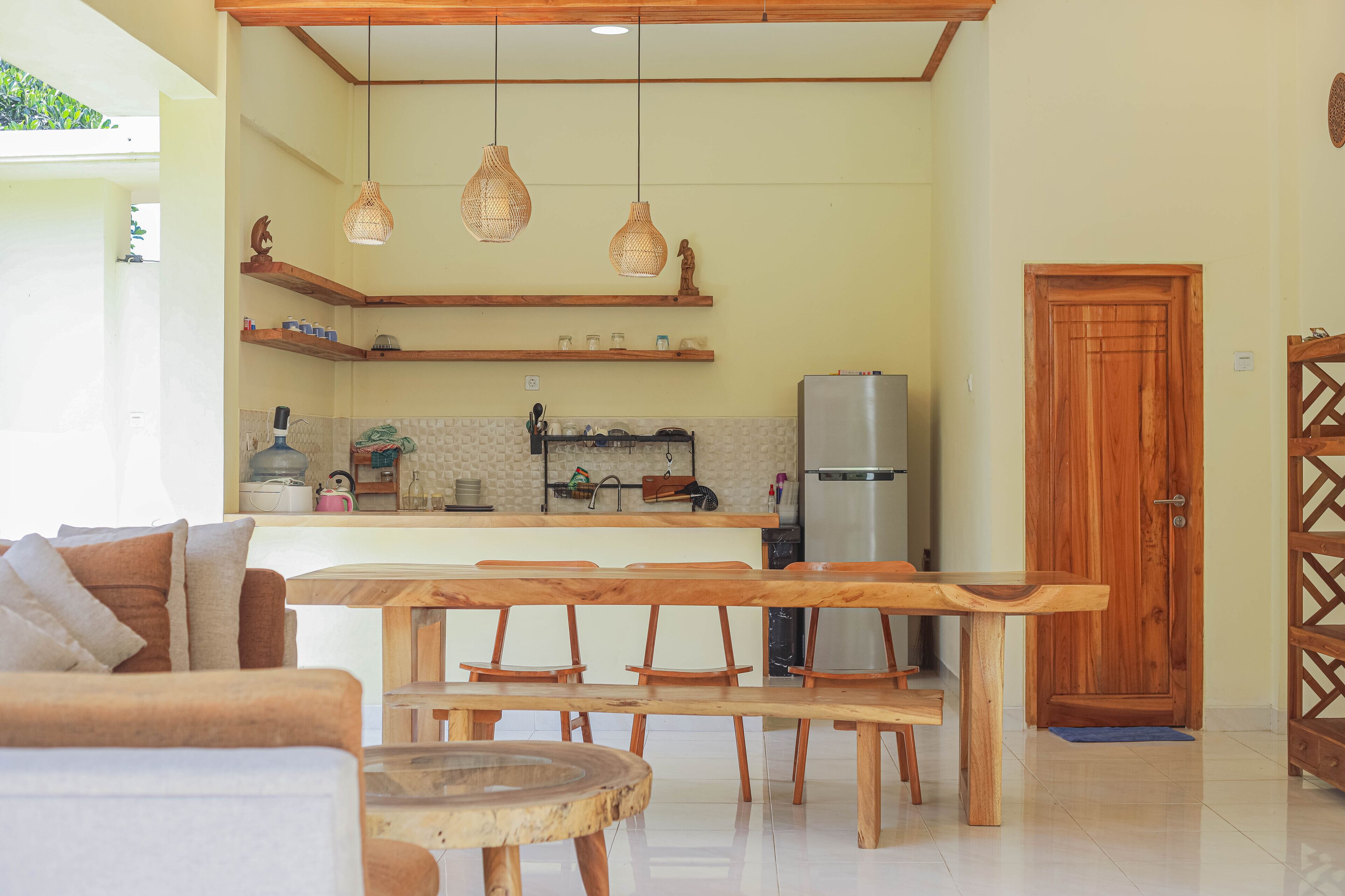 A modern kitchen with wooden shelves, hanging lights, and a central island.