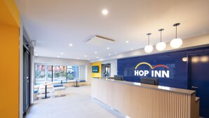 A reception area with a reception desk, seating area, and a large window providing a view of the outside. - HOP INN Tokyo Asakusa (Tokyo)