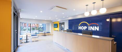 A reception area with a reception desk, seating area, and a large window providing a view of the outside.