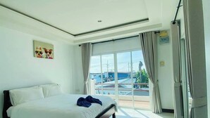 Un hotel moderno con una cama grande, un cuadro en la pared y vistas de la ciudad a través de la ventana.