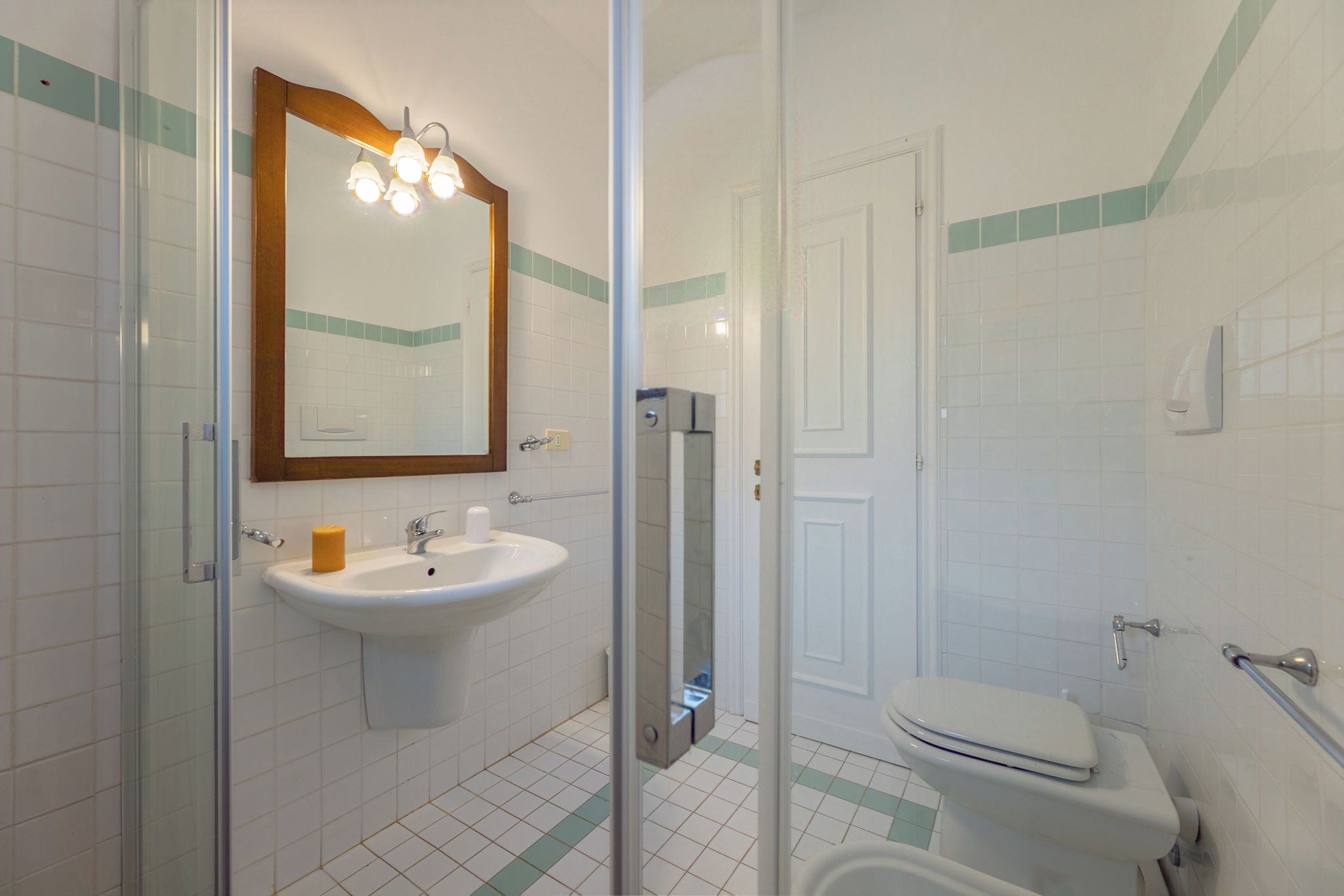 Une salle de bain avec une douche à parois de verre, un lavabo et des toilettes.