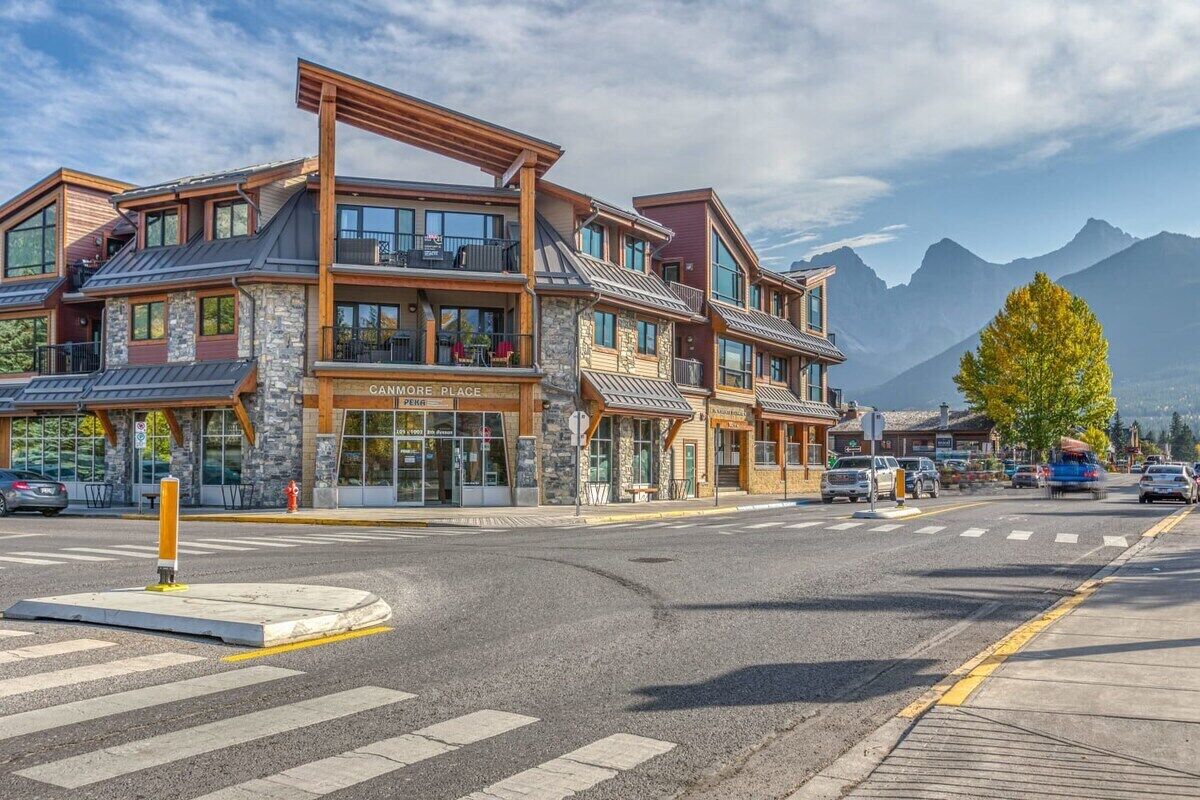 Un edificio de varios pisos con fachada de piedra, amplias ventanas y una entrada destacada.